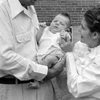 Man and woman with an infant outdoors.
