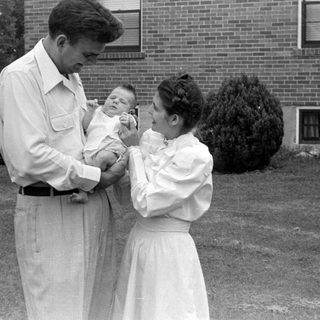 Man and woman with an infant outdoors.