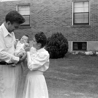 Man and woman with an infant outdoors.