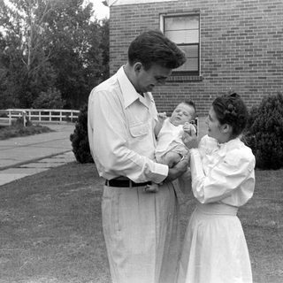 Man and woman with an infant outdoors.