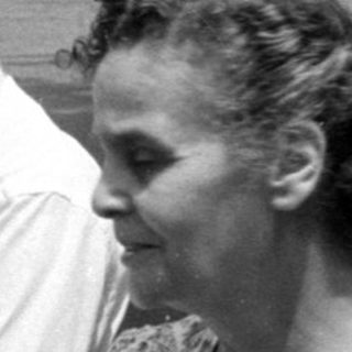Man and woman with an infant on a sidewalk.