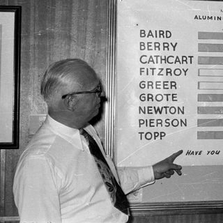 Man pointing to an aluminum sheet sales chart.