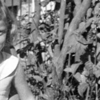 Woman and young girl lying in tall grass.