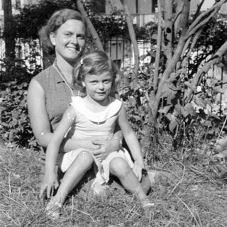 Woman and young girl lying in tall grass.