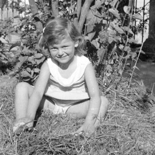 Young girl sitting on a pile of hay.