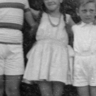 Six children standing in a row outdoors.