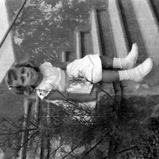 Young girl in a white dress on concrete steps.