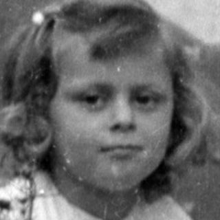 Young girl in a white dress on concrete steps.