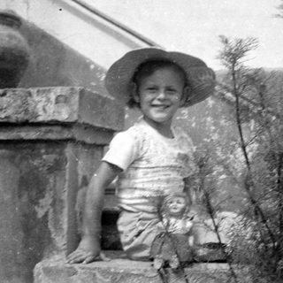 Child in a sun hat with a doll.