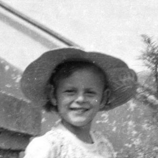 Child in a sun hat with a doll.