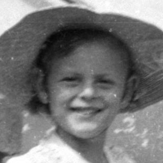 Child in a sun hat with a doll.