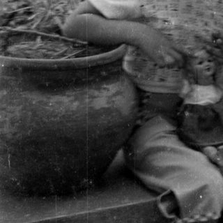 Smiling child holding a doll outdoors.