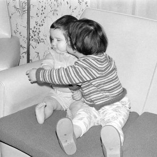 Two young children sitting on a sofa.