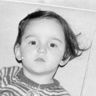 Two young children sitting on a sofa.