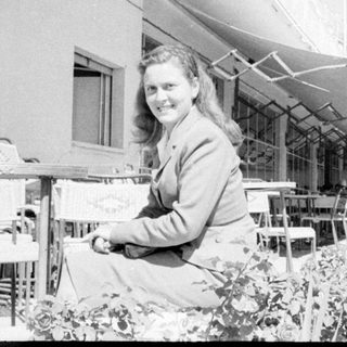 Person leaning out of a window in black and white.