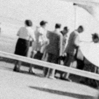 Woman posing in front of a propeller airplane.