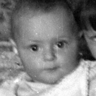 Two young children by a wicker bassinet.