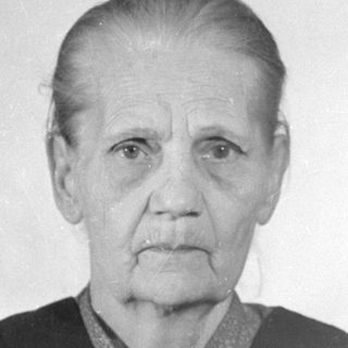 Portrait of an elderly woman in a dark vest.