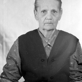 Portrait of an elderly woman in a dark vest.