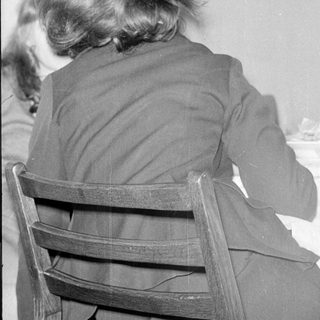 Rear view of a person sitting at a table.