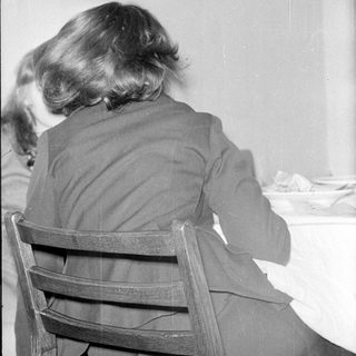 Rear view of a person sitting at a table.