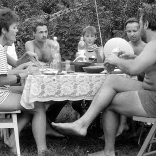 Four people gathered around a table in a garden.