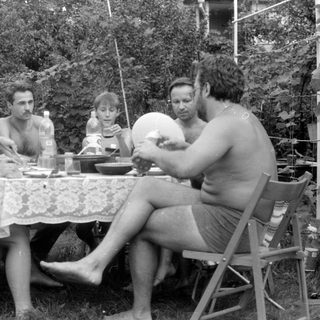 Four people gathered around a table in a garden.