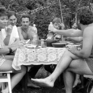 Group of people at an outdoor table with a balloon.