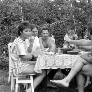 Group of people at an outdoor table with a balloon.