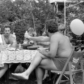 Group of people at an outdoor table with a balloon.