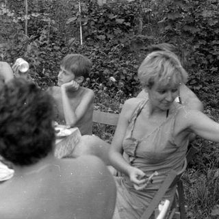 Group of people dining outdoors in a garden.