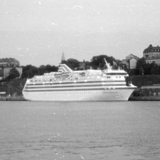 Cruise ship docked in a city harbor.
