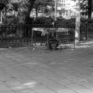 City sidewalk with metal table and advertising pillar.