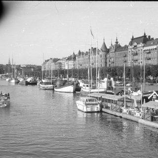 Waterfront with sailboats and ornate European architecture.