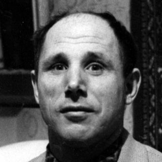 Man in blazer and bowtie in a domestic interior.