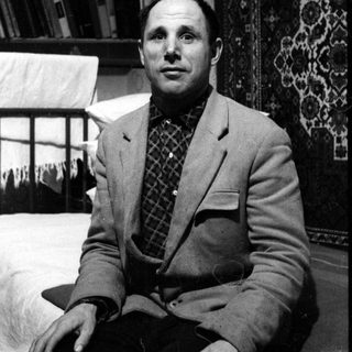 Man in blazer and bowtie in a domestic interior.