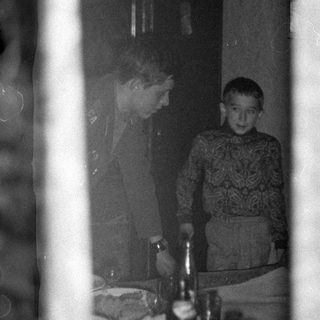 Woman and boy standing behind a set table.