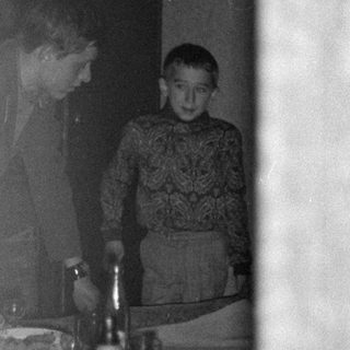 Woman and boy standing behind a set table.