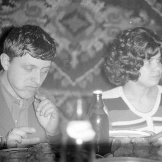 Man and woman at a table with bottles.