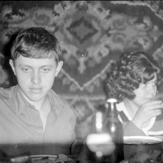 Man and woman sitting at a table indoors.
