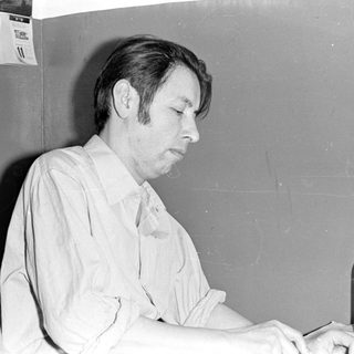 Man sitting at a table with a bottle and food.