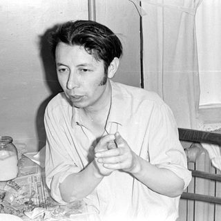 Man sitting at a table with a glass jar.