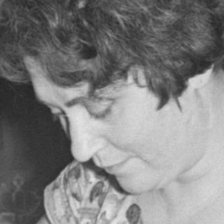 Woman at a table with a seltzer bottle.