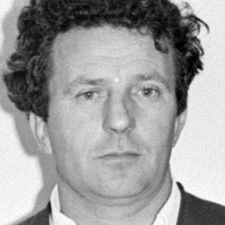 Portrait of a man in a suit, oriented vertically.