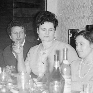 Five people seated at a dining table with drinks.