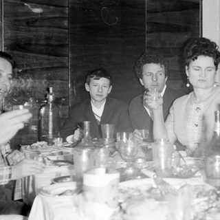 Five people seated at a dining table with drinks.