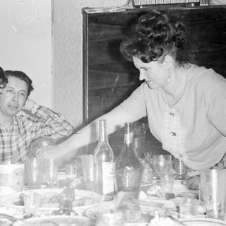 Three people seated at a table with glassware.