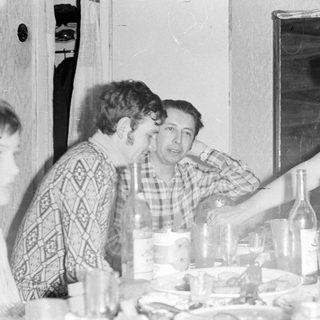 Three people seated at a table with glassware.