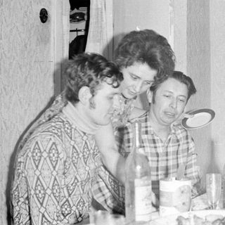 Three people at a table with a mirror reflection.