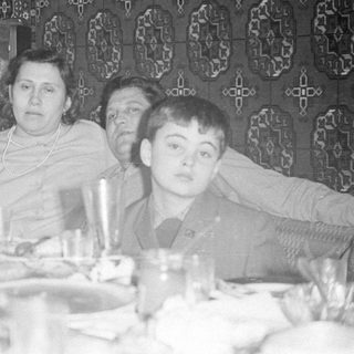 Four people seated at a set dining table.